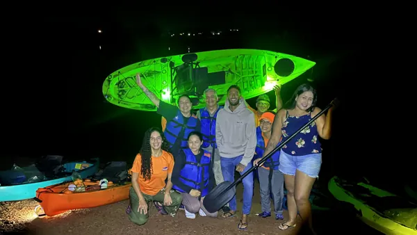 Grupo depois da remada noturna, com um caiaque iluminado de verde